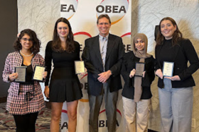 four award recipients pose with their awards at the OBEA Award Ceremony