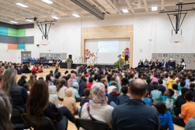 a large crowd celebrates the opening of Wazoson school in the school's gymnasium
