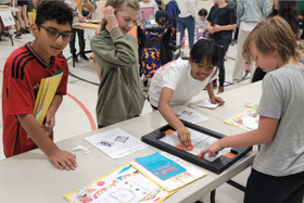 four John Young School students playing a board game
